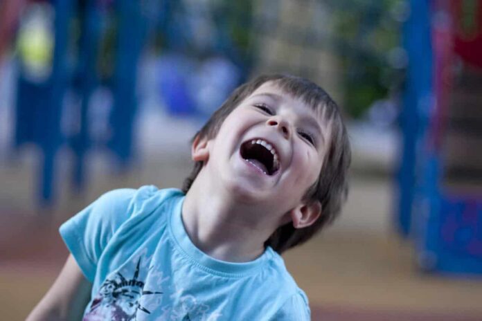 chłopiec śmiejący się na placu zabaw